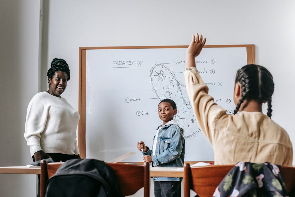 A teacher and students engaged in a science lesson in a classroom.
