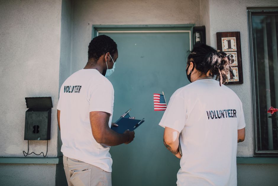 Two volunteers in matching t-shirts, representing membership and community outreach.
